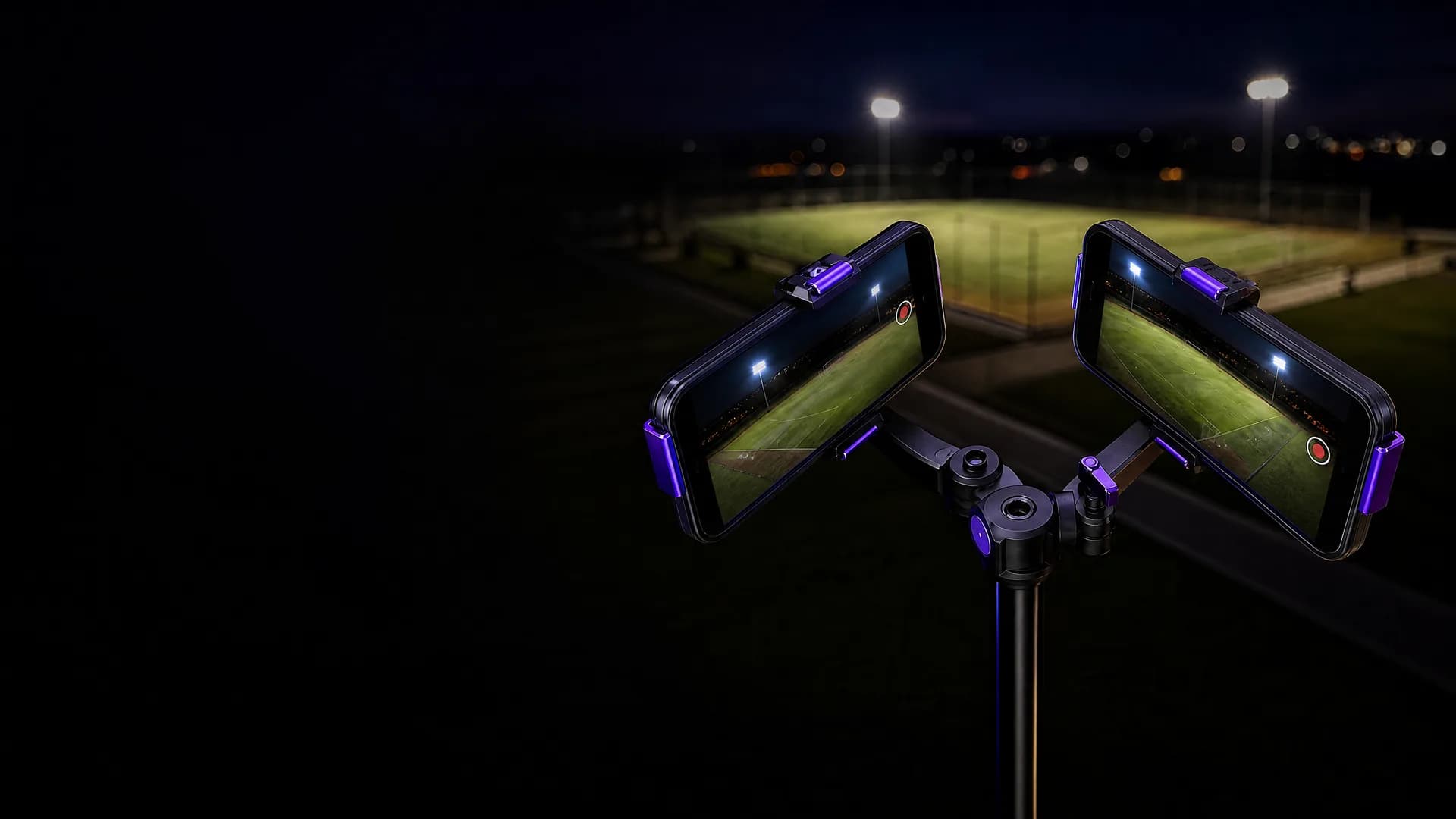 Two phones angled outward on a violet MatchCam mount, overlooking a football pitch
