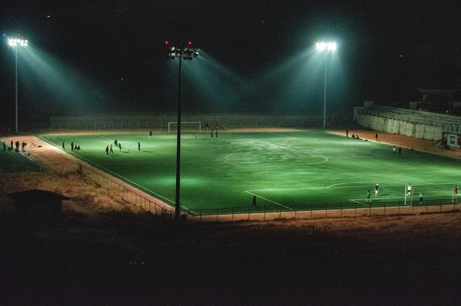 Floodlit football pitch at night seen from above